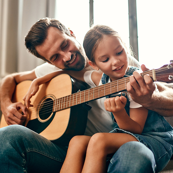 Dad-learning-his-girl-to-play-guitar