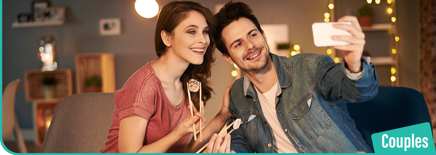 A-couple-on-a-date-night-taking-a-selfie-and-eating-sushi