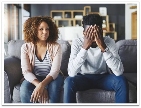 Couple sitting on a couch busy arguing